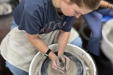 female student making pottery