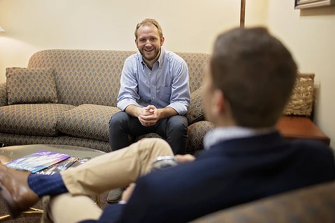 Two Men Conversing in Livingroom