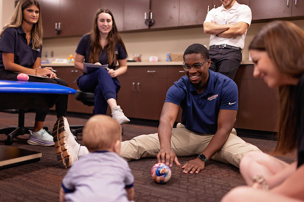 Students Playing Ball with Baby