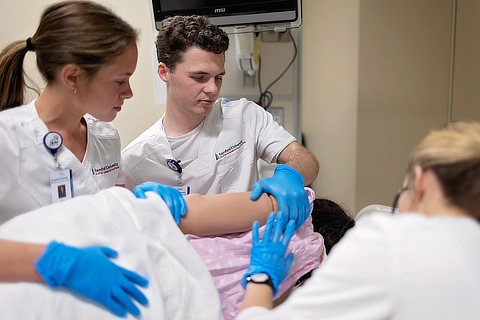 male and female nurses with a professor