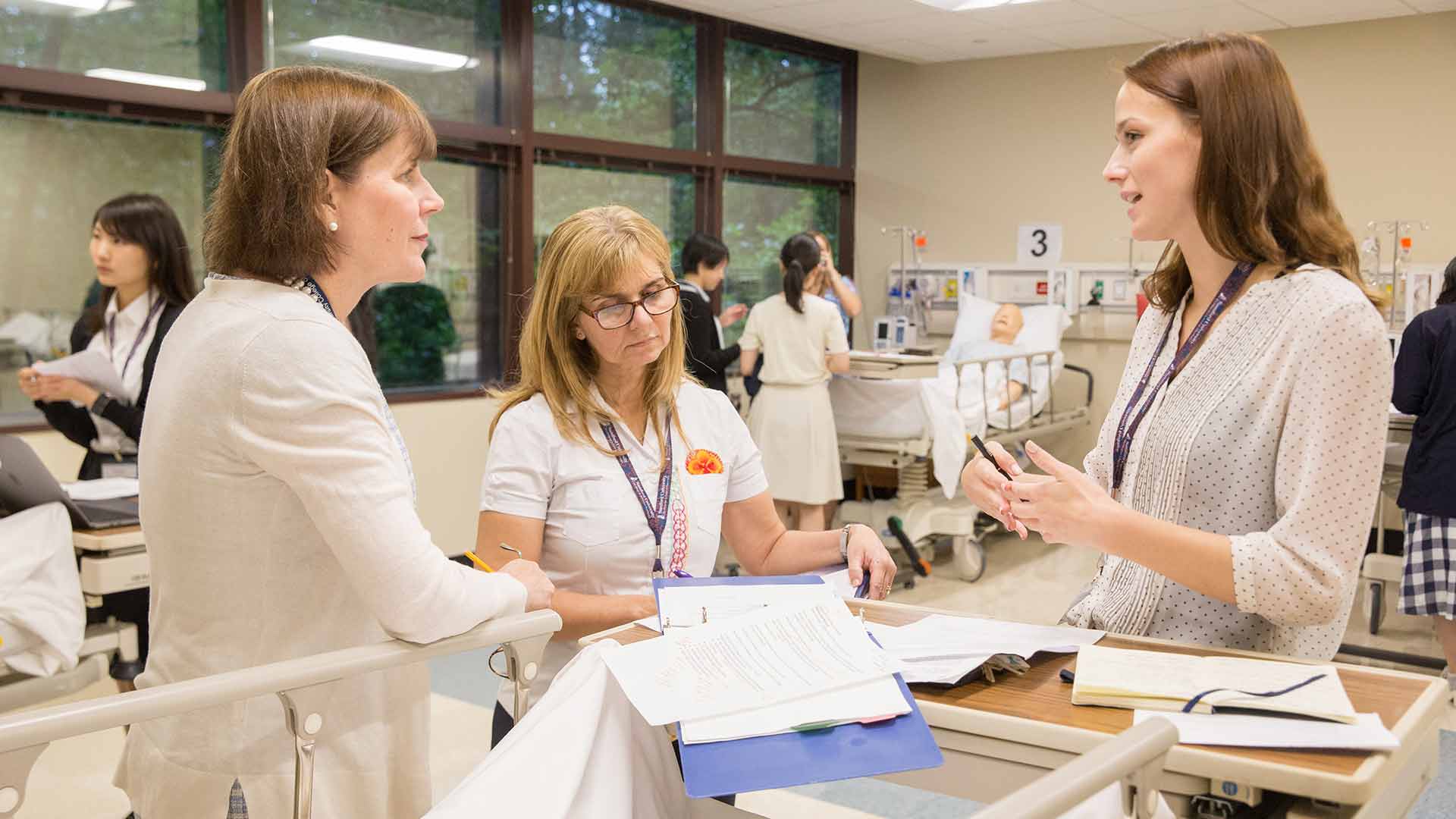 white female pharmacy student explaining in simulation lab