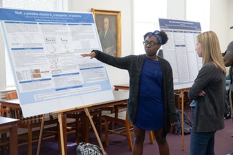 female student explaining her research BC04198219