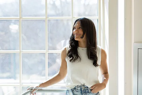 female student standing by a window
